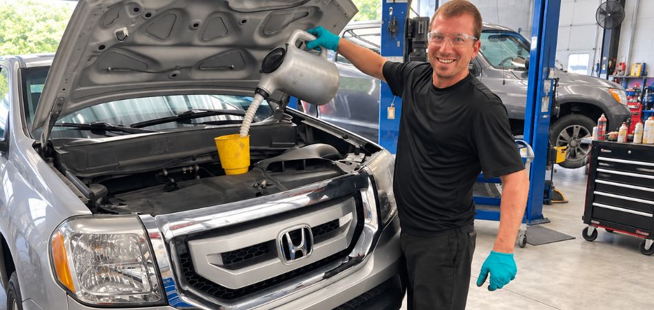 Pouring engine oil during Honda CR-V service in the Charleston shop