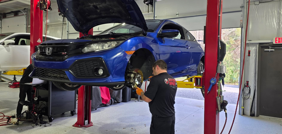 Honda Civic Si receiving brake service at an auto repair shop